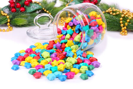 Paper stars with dreams in jar on white background