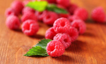 Ripe sweet raspberries on wooden background