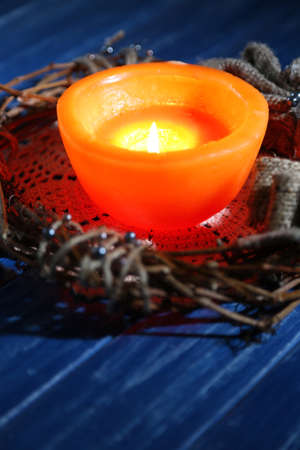 Burning candle with Christmas decorations on color wooden backgroundの写真素材