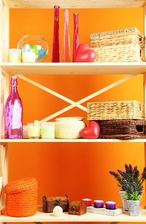Beautiful white shelves with different home related objects, on color wall backgroundの写真素材