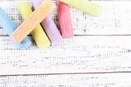 Chalks in variety of colors, on wooden background