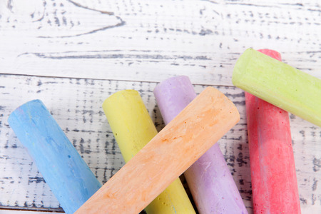 Chalks in variety of colors, on wooden background