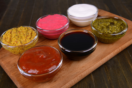 Various sauces on chopping board on table close-upの写真素材
