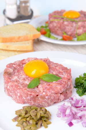 Delicious steak tartare with yolk on plate on table close-upの写真素材