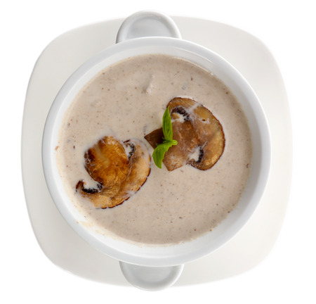 Mushroom soup in white bowl, on plate, isolated on whiteの写真素材