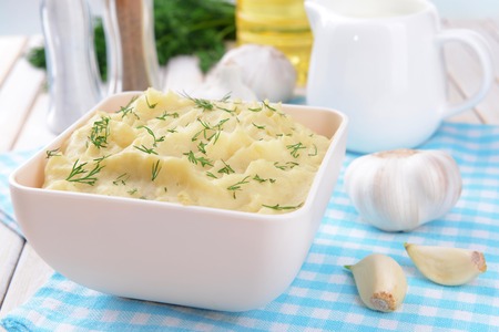 Delicious mashed potatoes with greens in bowl on table close-upの写真素材