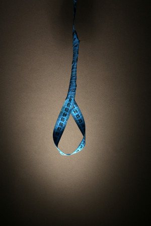 Tape measure noose on grey background - diet conceptの写真素材