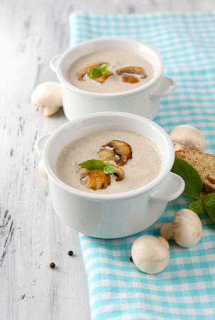 Mushroom soup in white pots, on napkin,  on wooden の写真素材