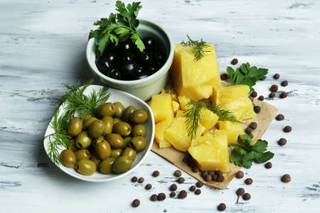 Parmesan cheese, fresh herbs and olives on wooden backgroundの写真素材
