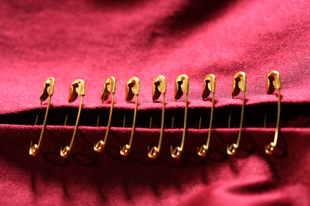 Safety pins on fabric backgroundの写真素材