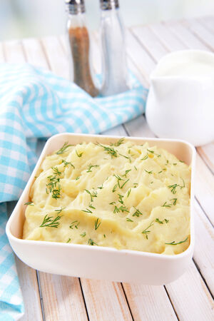 Delicious mashed potatoes with greens in bowl on table close-upの写真素材