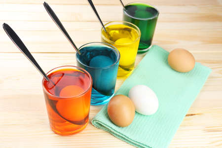 Glasses with paint for Easter eggs and eggs, close upの写真素材