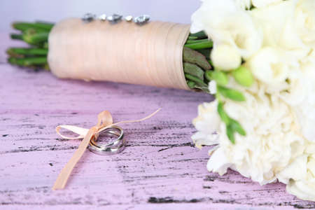Beautiful wedding bouquet and rings on wooden backgroundの写真素材