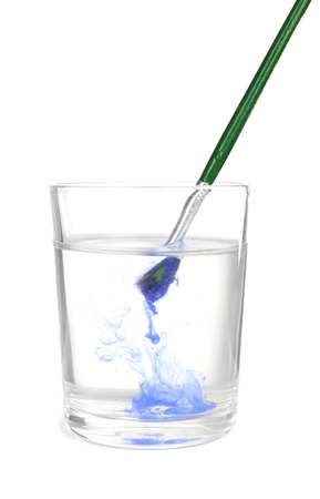 Brush with color paint in glass of water, isolated on whiteの写真素材