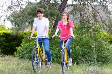 Young couple on bicycles in parkの写真素材