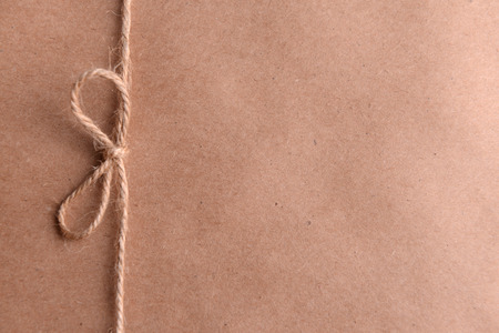 String tied in  bow on brown paper packaging close-upの写真素材