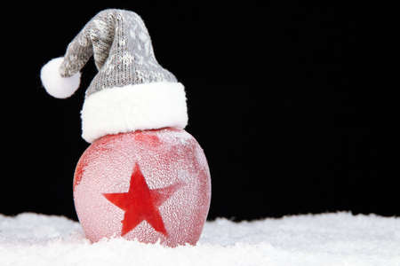 Holiday apple with frosted star in snow on black backgroundの写真素材