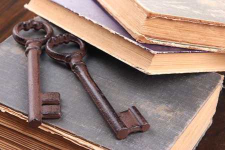 Old keys on old books on wooden backgroundの写真素材