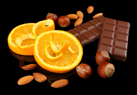 Chocolate, orange and nuts on black backgroundの写真素材