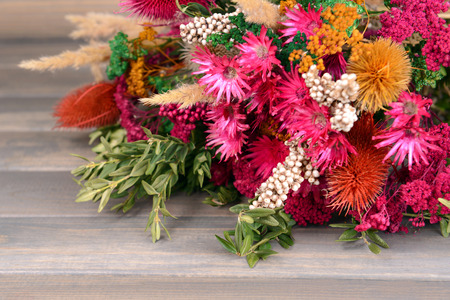 Beautiful bouquet of bright flowers on wooden backgroundの写真素材