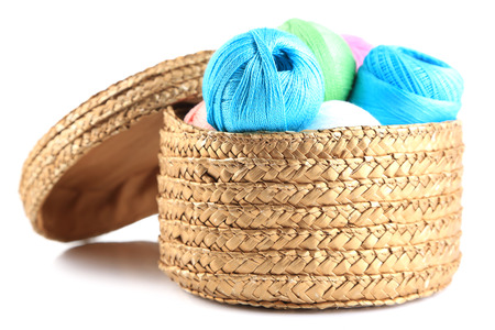 Colorful yarn balls for knitting in wicker basket, isolated on whiteの写真素材