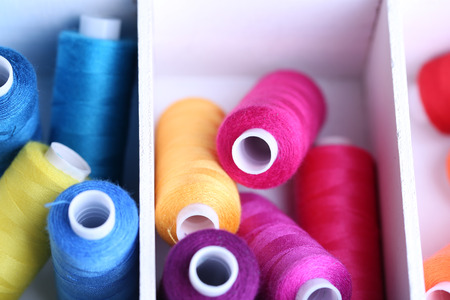 Multicolor sewing thread in wooden box, close-up