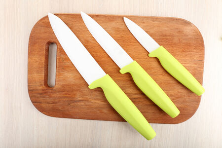 Kitchen knives and cutting board on wooden tableの写真素材
