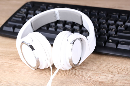 Headphone and keyboard close-up on wooden desk backgroundの写真素材