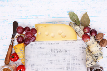 Different types of cheese with empty board on table close-upの写真素材
