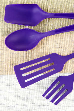 Plastic kitchen utensils on fabric backgroundの写真素材
