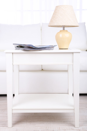 Magazines and lamp on coffee table in roomの写真素材