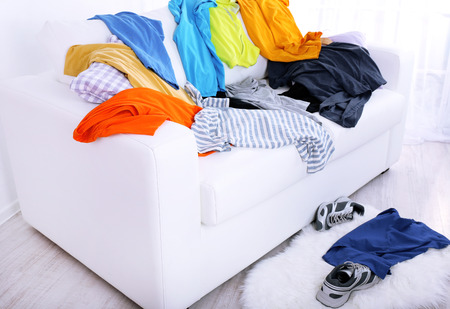 Messy colorful male clothing on  sofa on light backgroundの写真素材