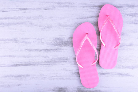 Bright flip-flops on color wooden backgroundの写真素材