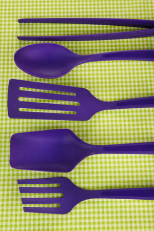 Plastic kitchen utensils on fabric backgroundの写真素材