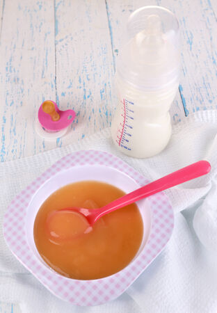 Baby food and milk on wooden tableの写真素材