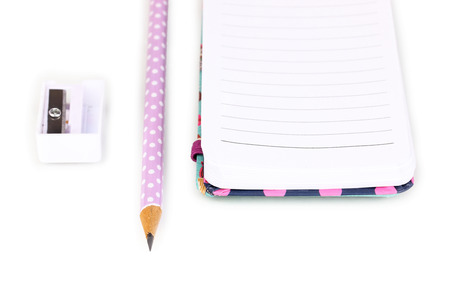 Pencil, pencil sharpener and notepad isolated on white
