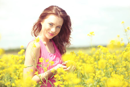 Beautiful young woman with cherries in field