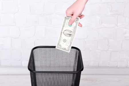 Throwing away your money on grey wall backgroundの写真素材