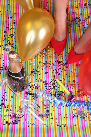 Legs with confetti, champagne and balloons on the floorの写真素材