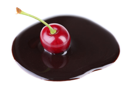 Cherry  in chocolate sauce isolated on whiteの写真素材