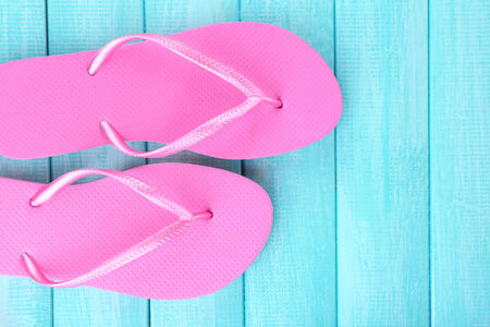 Bright flip-flops on color wooden backgroundの写真素材