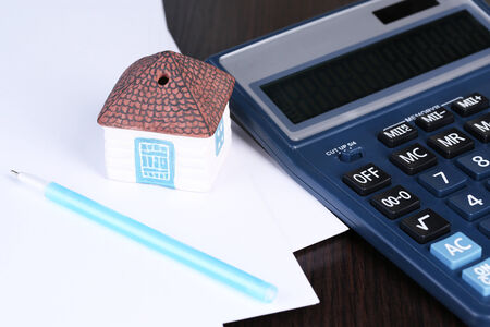 Toy house and calculator on table close-upの写真素材