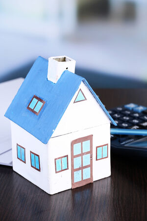Toy house and calculator on table close-upの写真素材