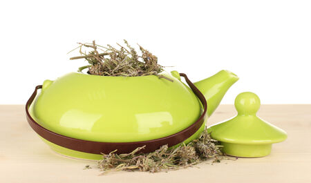 Dried herbs in teapot on wooden table, isolated on white. Conceptual photo of herbal tea.の写真素材