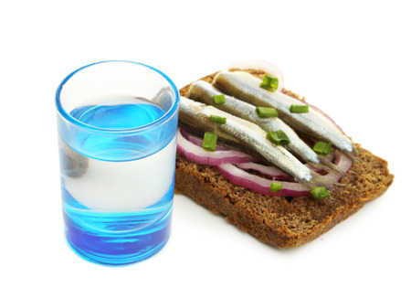 Composition with glass of vodka, and  sandwiches wit salted fish, isolated on whiteの写真素材