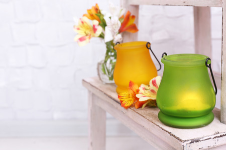 Bright icon-lamps with flowers on wooden ladder on light backgroundの写真素材