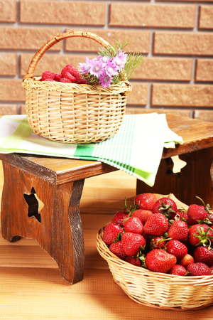 Fresh berries in baskets on wall backgroundの写真素材