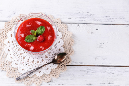 Strawberry, kiwi fruit and raspberry smoothies in glass bowl on color wooden background