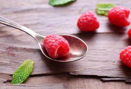 Ripe sweet raspberries in spoon on table close-upの写真素材