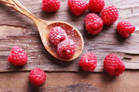 Ripe sweet raspberries in spoon on table close-upの写真素材